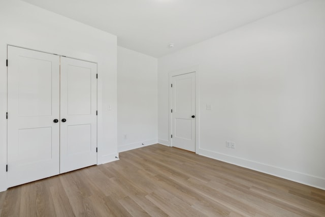 unfurnished bedroom featuring a closet and light hardwood / wood-style floors