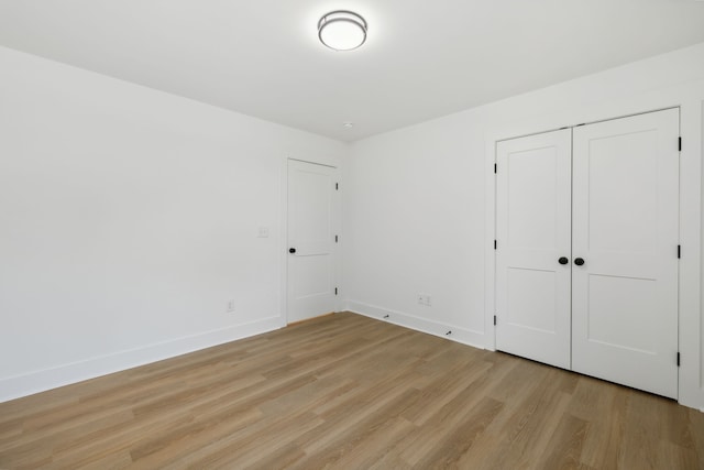 unfurnished bedroom featuring a closet and light hardwood / wood-style floors