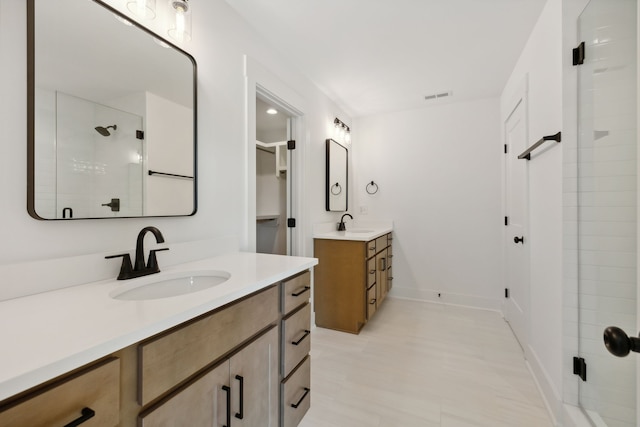 bathroom featuring vanity and a shower with door