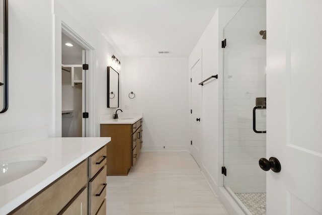 bathroom featuring vanity and a shower with door