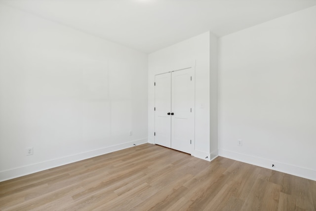 unfurnished bedroom with a closet and light wood-type flooring