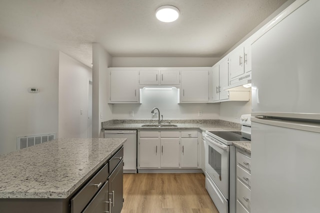 kitchen with visible vents, light wood-type flooring, a sink, under cabinet range hood, and white appliances