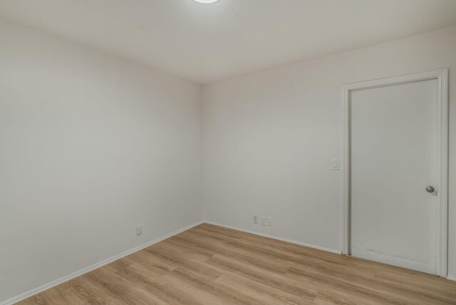 spare room with light wood-style flooring and baseboards