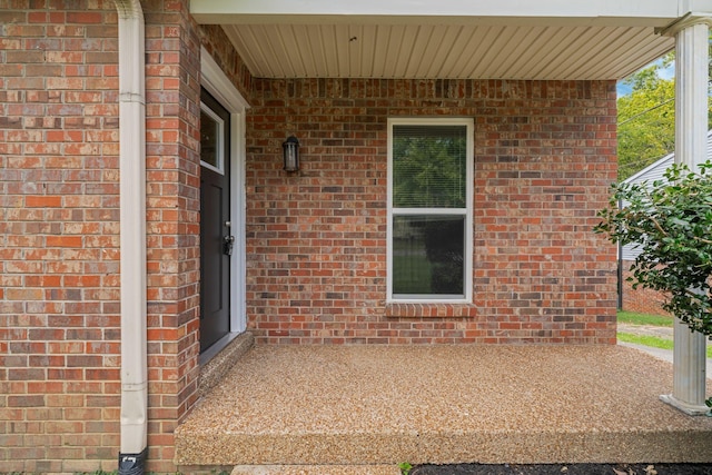 doorway to property featuring brick siding