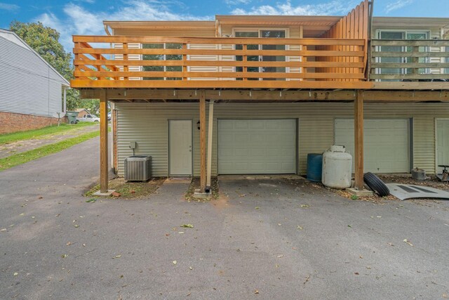 garage featuring aphalt driveway and central AC unit