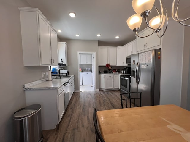 kitchen featuring appliances with stainless steel finishes, sink, a notable chandelier, dark hardwood / wood-style floors, and white cabinetry