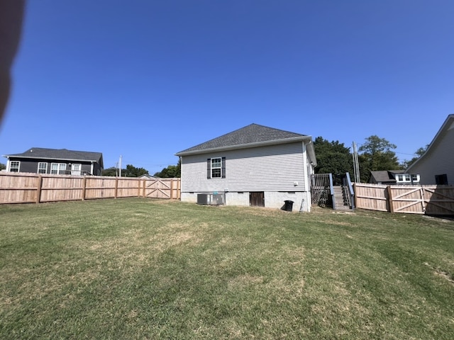 rear view of property featuring a yard and central AC