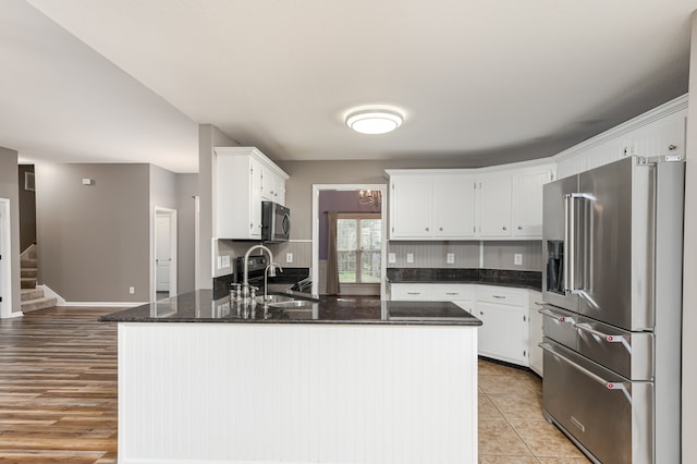 kitchen featuring white cabinetry, sink, high end refrigerator, kitchen peninsula, and light wood-type flooring