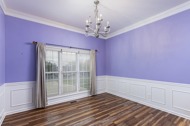 spare room featuring crown molding, dark hardwood / wood-style floors, and a notable chandelier