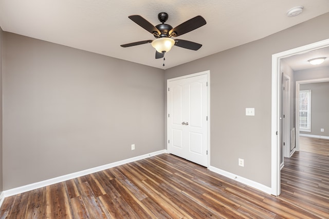 unfurnished bedroom featuring ceiling fan, dark hardwood / wood-style flooring, and a textured ceiling