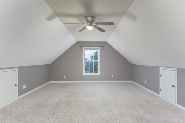 additional living space featuring carpet floors, vaulted ceiling, and ceiling fan