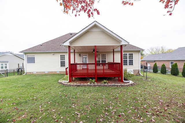 back of house featuring ceiling fan, a deck, and a yard