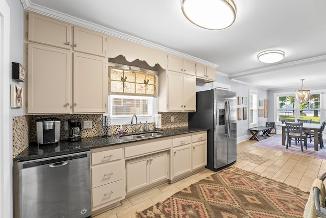 kitchen featuring cream cabinets, appliances with stainless steel finishes, ornamental molding, sink, and decorative backsplash