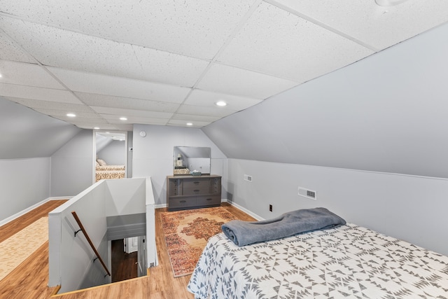 bedroom with vaulted ceiling, wood-type flooring, and a drop ceiling