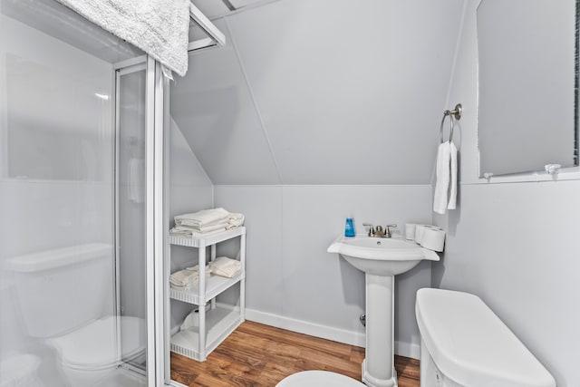 bathroom with a shower with door, toilet, hardwood / wood-style flooring, and lofted ceiling