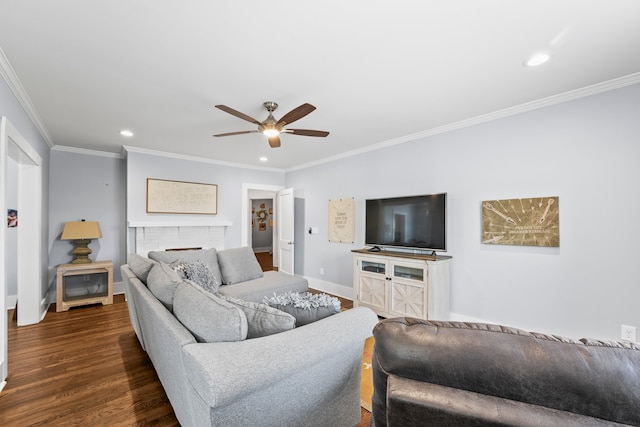 living room with a fireplace, crown molding, ceiling fan, and dark hardwood / wood-style floors