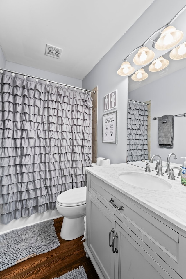 full bathroom featuring vanity, toilet, hardwood / wood-style flooring, and shower / tub combo