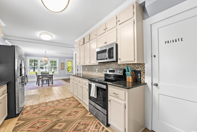 kitchen with dark stone countertops, appliances with stainless steel finishes, light hardwood / wood-style floors, a chandelier, and tasteful backsplash