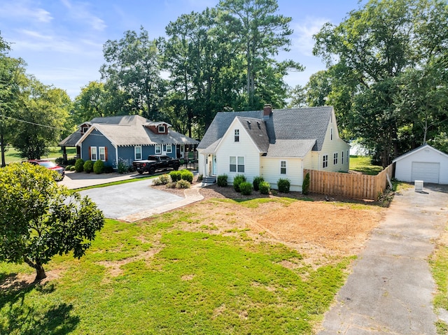 view of front of house with a garage, a front lawn, and an outbuilding