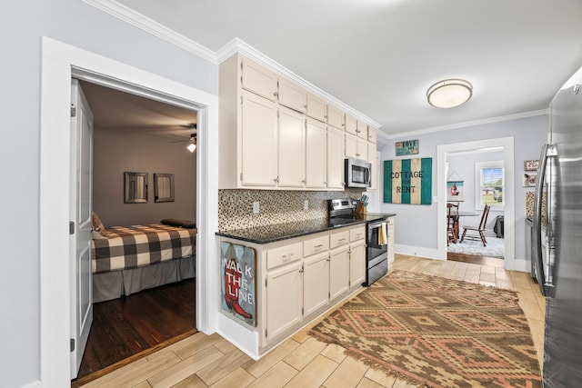 kitchen featuring light wood-type flooring, stainless steel appliances, ceiling fan, decorative backsplash, and ornamental molding