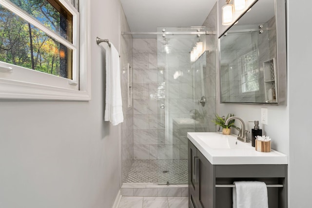 full bathroom featuring vanity, baseboards, a stall shower, and marble finish floor