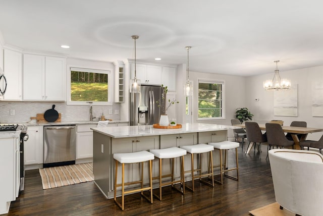 kitchen with stainless steel appliances, dark wood-style floors, a center island, and white cabinets