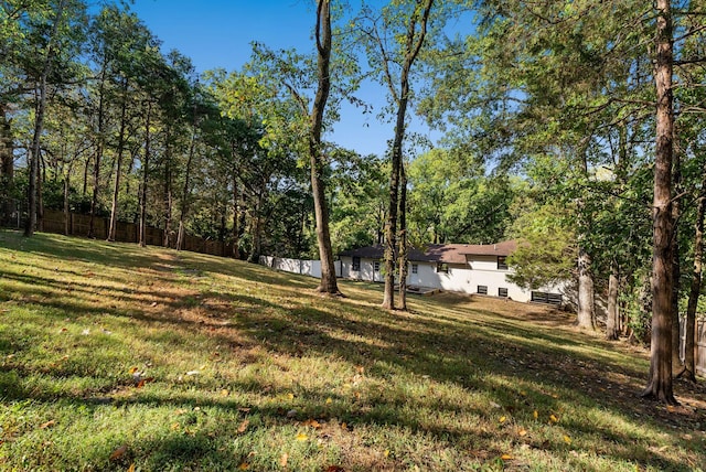 view of yard with a forest view and fence