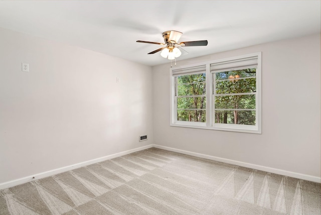 empty room with a ceiling fan, light colored carpet, and baseboards