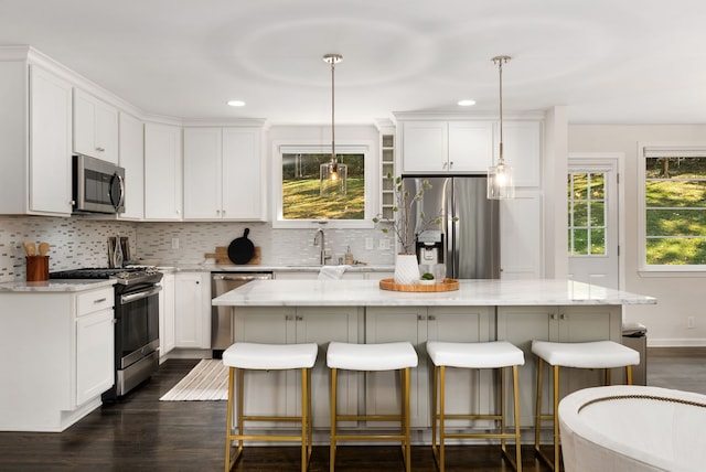 kitchen with a kitchen island, stainless steel appliances, and light stone countertops