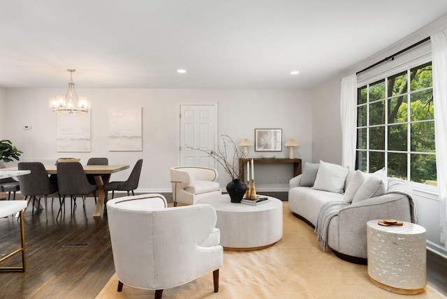 living area with recessed lighting, baseboards, an inviting chandelier, and wood finished floors