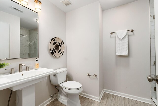 full bath featuring visible vents, baseboards, toilet, a stall shower, and wood finished floors