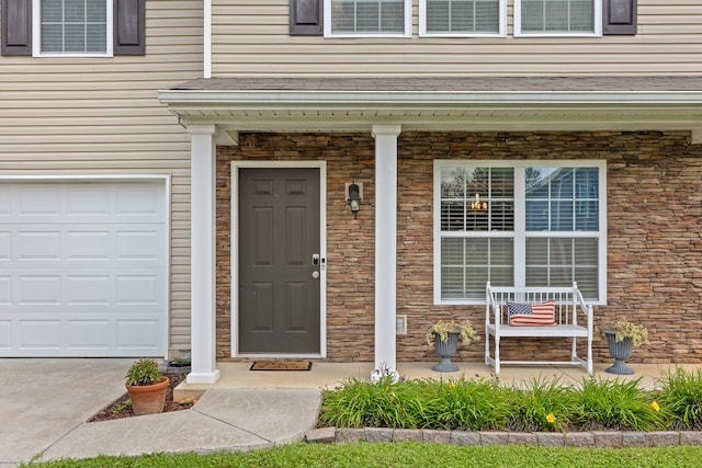 entrance to property featuring a garage and a porch