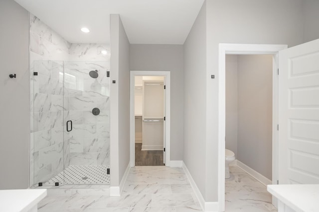 bathroom featuring toilet and a shower with door