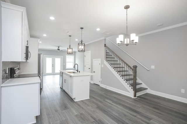 kitchen with decorative light fixtures, dark hardwood / wood-style flooring, a kitchen island with sink, stainless steel dishwasher, and white cabinetry