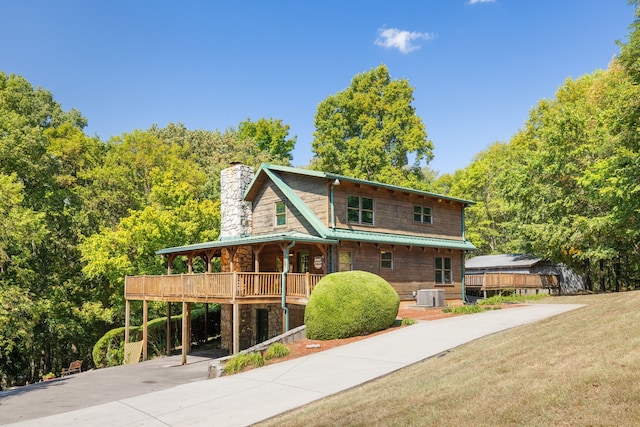 view of front of house with cooling unit, a porch, and a front yard