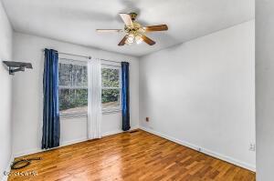 unfurnished room with wood finished floors and a ceiling fan