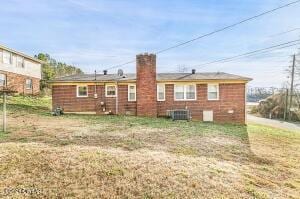 back of property featuring cooling unit and a chimney