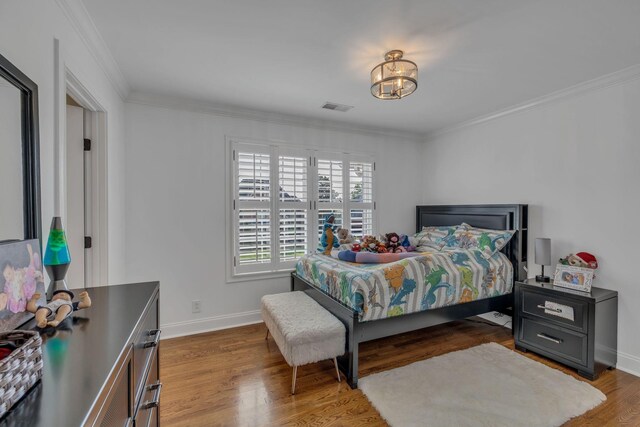 bedroom featuring dark wood-type flooring, a chandelier, and crown molding