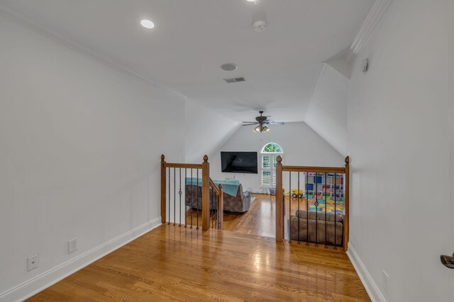 bedroom featuring lofted ceiling, crown molding, and light hardwood / wood-style floors