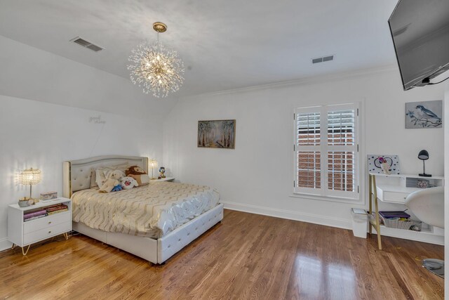 bedroom featuring hardwood / wood-style floors, a chandelier, crown molding, and vaulted ceiling