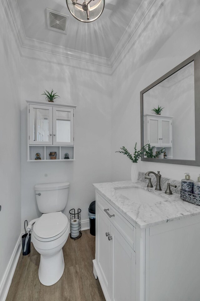 bathroom featuring crown molding, vanity, toilet, and hardwood / wood-style flooring