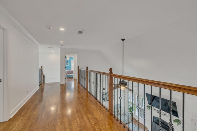 hall with light wood-type flooring and crown molding