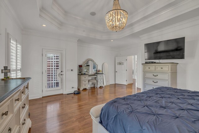 bedroom featuring dark wood-type flooring, a tray ceiling, and ornamental molding