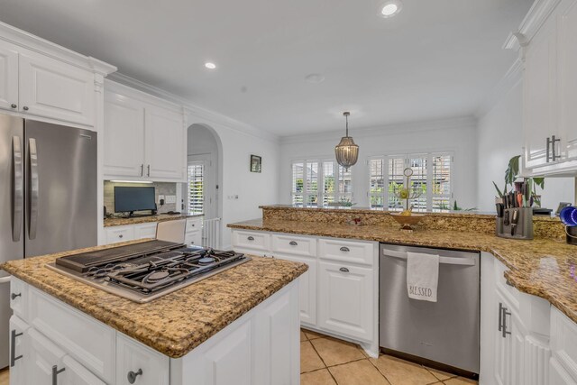 kitchen with light tile patterned floors, a center island, stainless steel appliances, light stone counters, and white cabinets