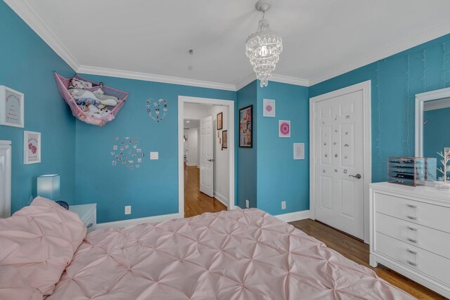 bedroom featuring a notable chandelier, hardwood / wood-style flooring, and crown molding