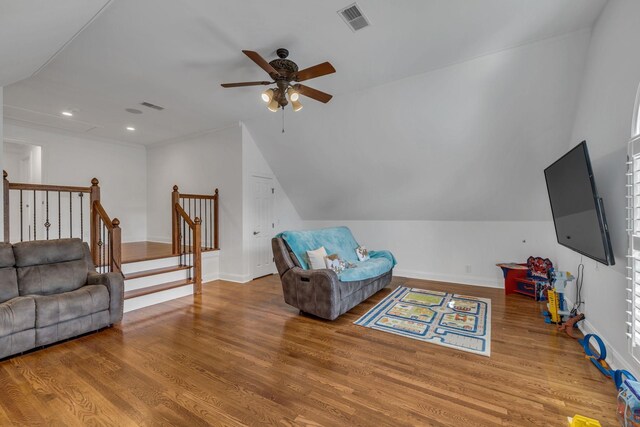 living room with wood-type flooring, vaulted ceiling, and ceiling fan