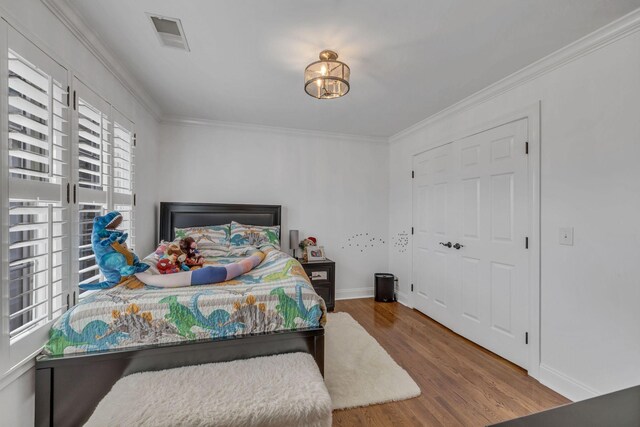 bedroom featuring ornamental molding and hardwood / wood-style flooring