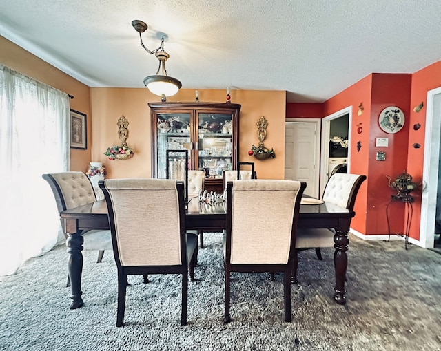 dining area featuring a textured ceiling and dark carpet