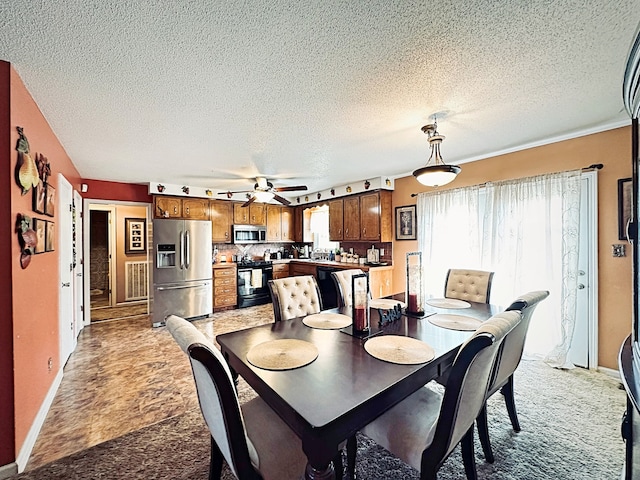 carpeted dining area featuring a textured ceiling and ceiling fan