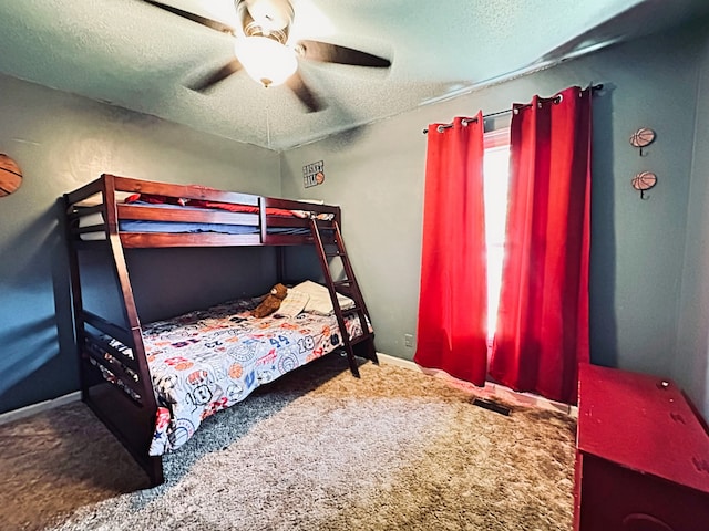 bedroom with a textured ceiling, carpet flooring, and ceiling fan